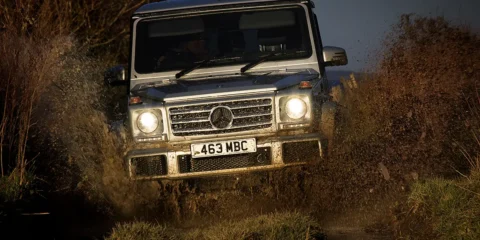 Mercedes G-Class driving through a forest terrain