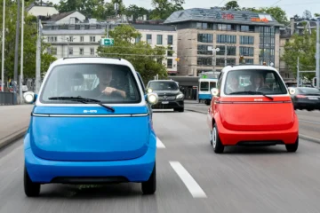 Microlino small electric cars on dual carriageway