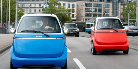 Microlino small electric cars on dual carriageway