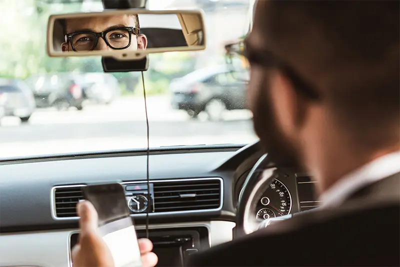 Driver holding a mobile phone while driving