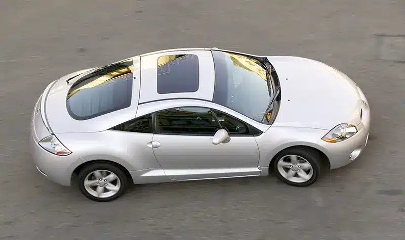 Aerial view of a silver classic Mitsubishi Eclipse coupe, showcasing its sleek lines and sporty design.