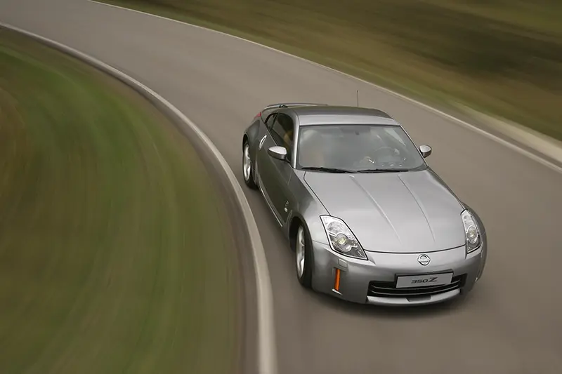 Silver Nissan 350Z on a race track, showing off its sporty design and performance capabilities.