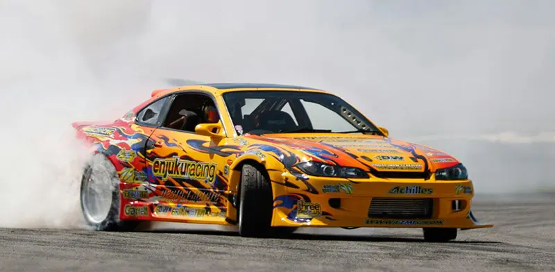 customised Mitsubishi ricer car wheelspins on a race track