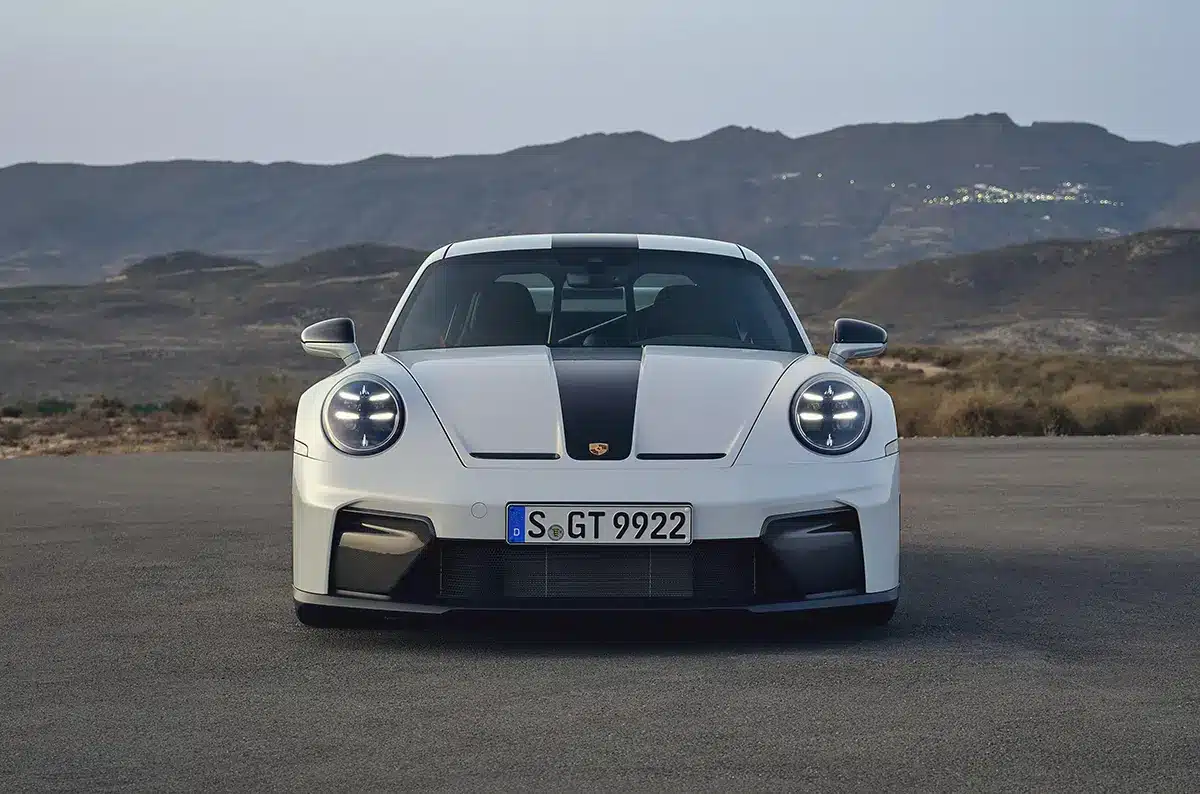 Front view of a white 2024 Porsche 911 GT Weissach Package, showcasing its distinctive aerodynamic design.