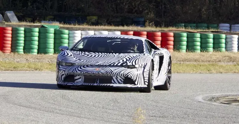 Bertone GB110 hypercar with black and white stripes taking a bend on a racetrack