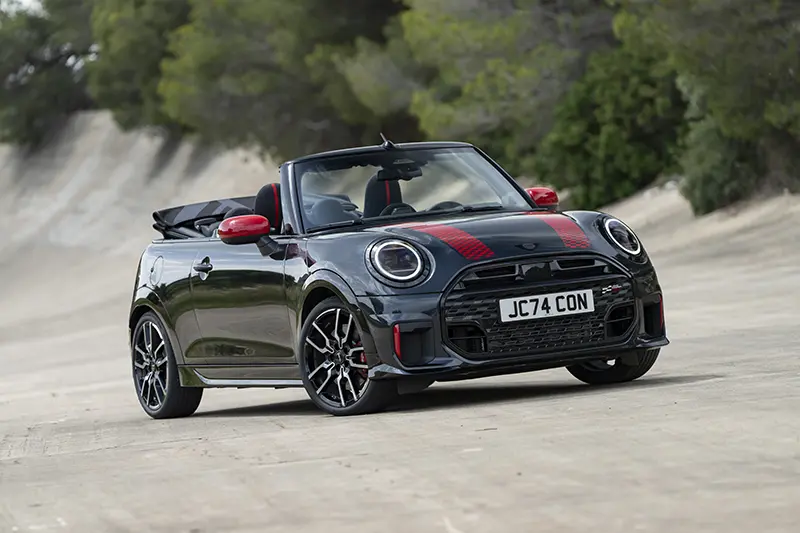 3/4 front profile of Mini John Cooper Works Cabriolet parked on a test track, emphasizing its bold design.