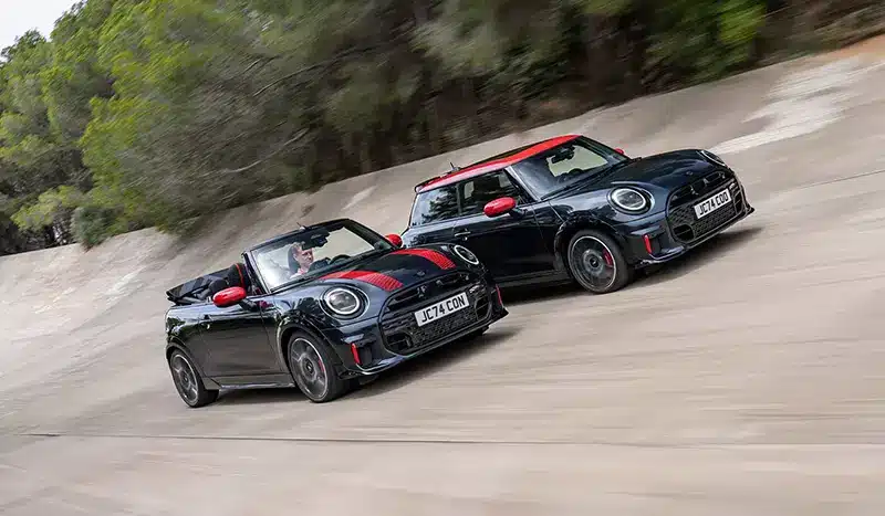 Mini JCW Hatchback and Cabriolet driving side by side, showcasing their sporty appeal.