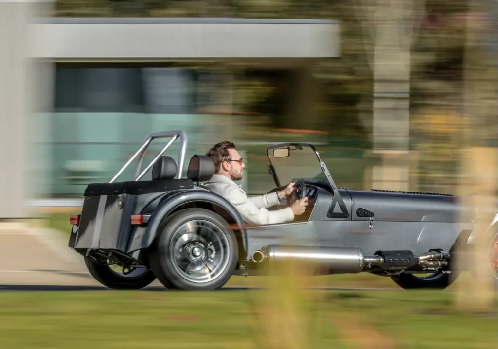 Side profile of the Caterham Seven CSR Twenty driving through scenic countryside.