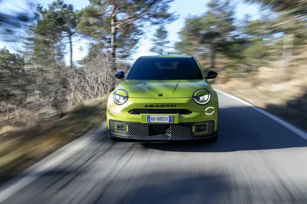 Front view of the Abarth 600e Scorpionissima driving on a UK country road