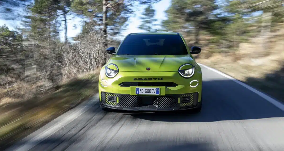 Front view of the Abarth 600e Scorpionissima driving on a UK country road