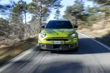 Front view of the Abarth 600e Scorpionissima driving on a UK country road