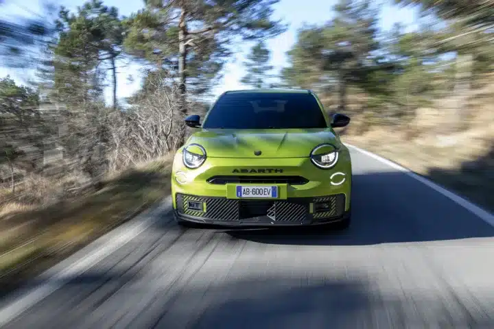 Front view of the Abarth 600e Scorpionissima driving on a UK country road