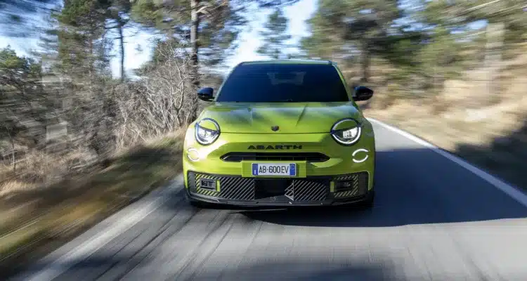 Front view of the Abarth 600e Scorpionissima driving on a UK country road