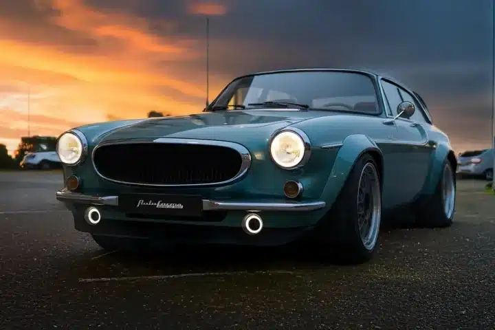 Autoforma Norrsken Volvo P1800 ES Restomod photographed from the front at sunset showing widened arches, LED lighting and classic Volvo styling