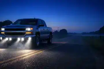 Modern pickup truck with LED auxiliary pod lights illuminating a rural road at dusk to improve nighttime driving visibility