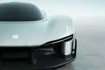 Front close-up of the Xiaomi Vision Gran Turismo concept car showing the MI logo, teardrop cockpit, and carbon fiber aerodynamic splitter.