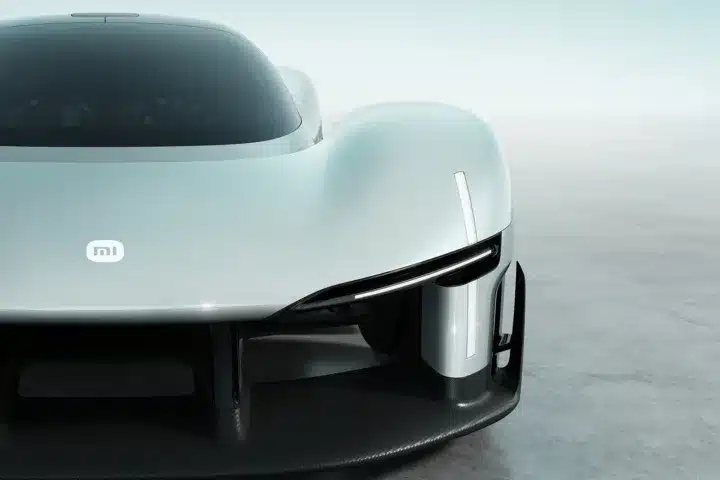 Front close-up of the Xiaomi Vision Gran Turismo concept car showing the MI logo, teardrop cockpit, and carbon fiber aerodynamic splitter.