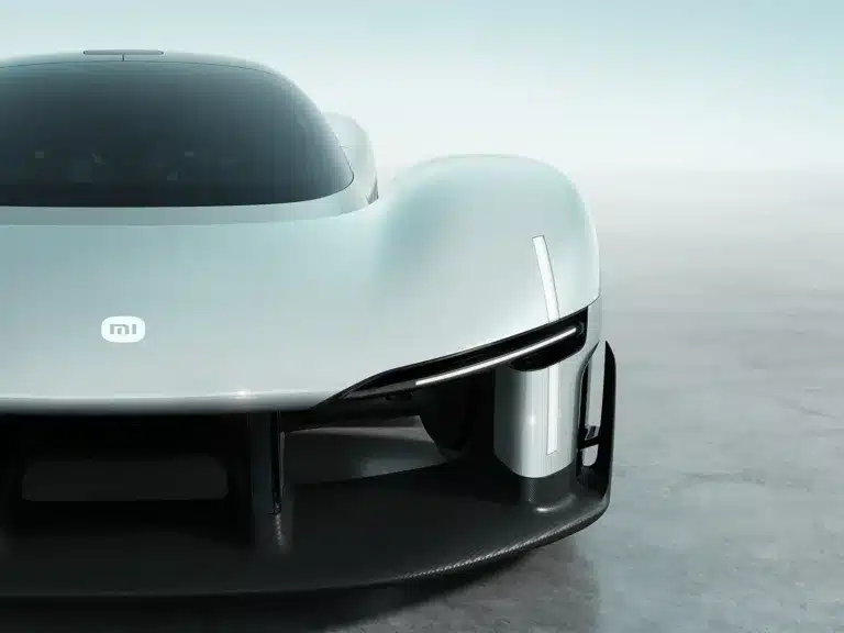 Front close-up of the Xiaomi Vision Gran Turismo concept car showing the MI logo, teardrop cockpit, and carbon fiber aerodynamic splitter.