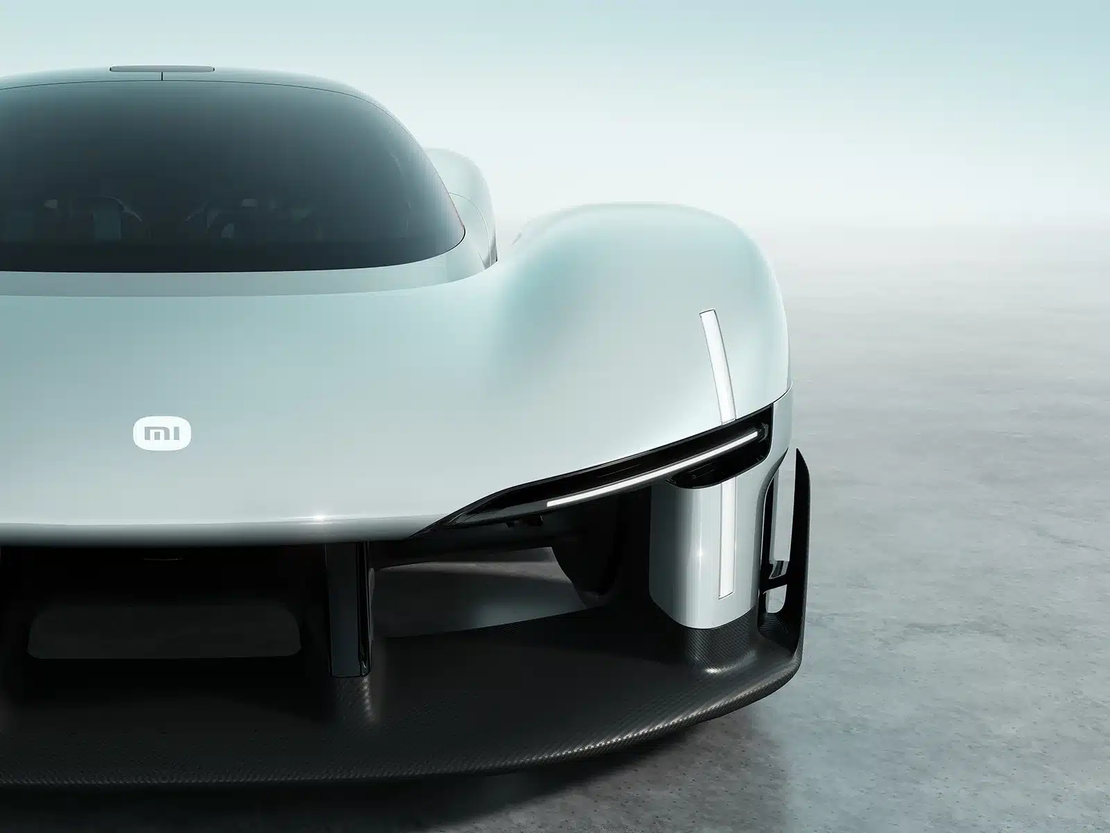 Front close-up of the Xiaomi Vision Gran Turismo concept car showing the MI logo, teardrop cockpit, and carbon fiber aerodynamic splitter.