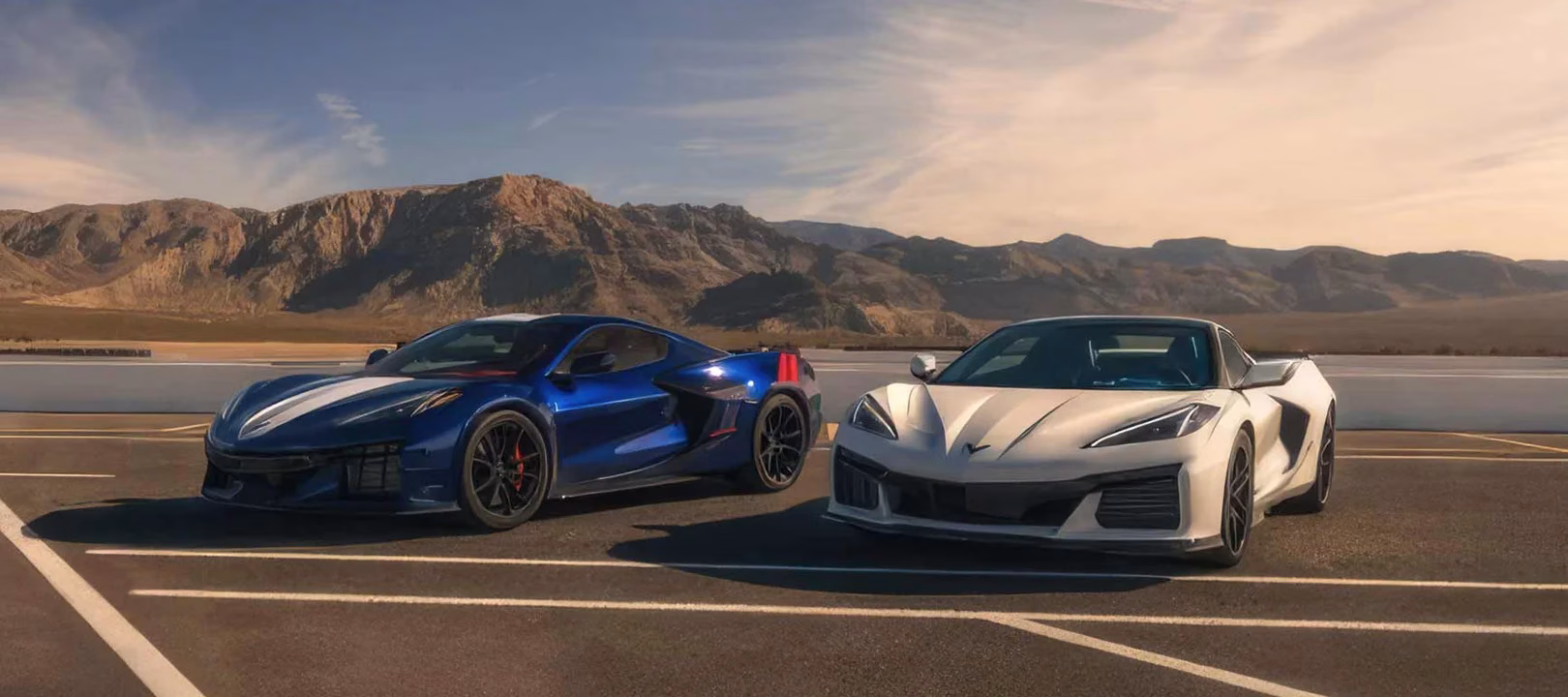 Blue and white 2027 Chevrolet Corvette Grand Sport models parked together on a mountain circuit