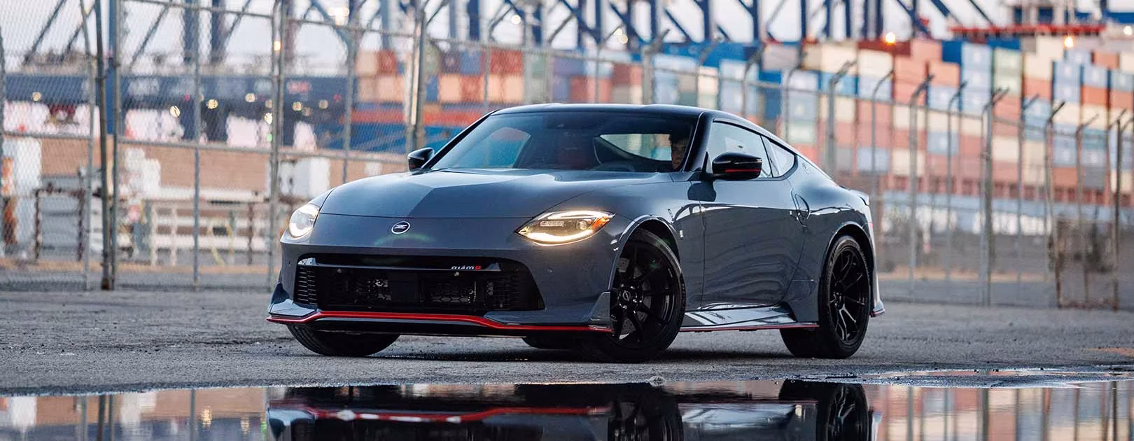 Grey Nissan Z NISMO front three-quarter view at an industrial port