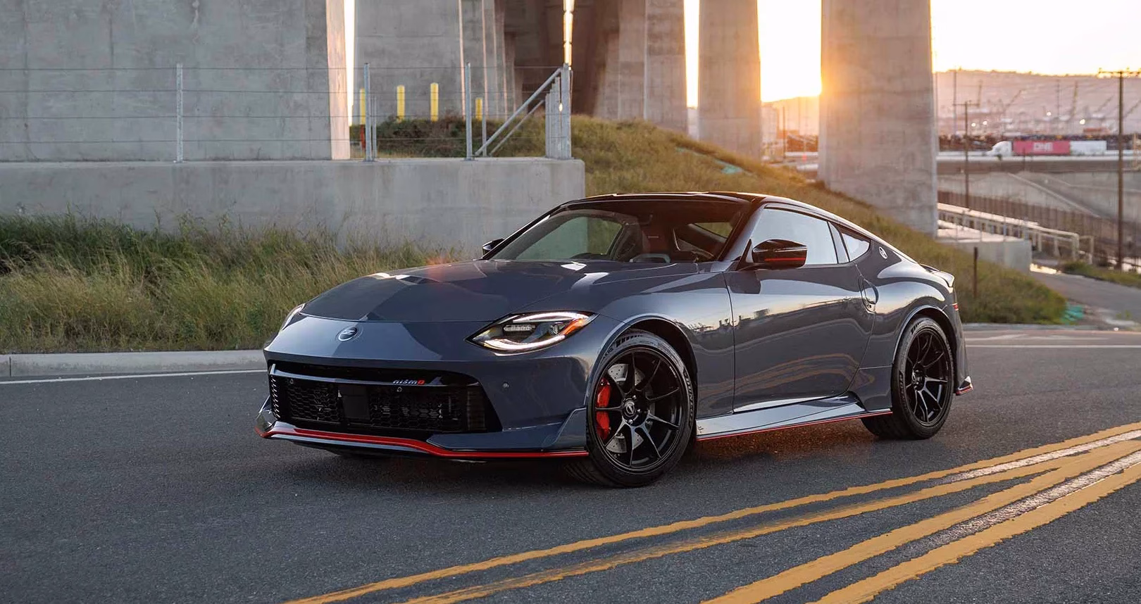 Grey Nissan Z NISMO on a curved road beneath a concrete bridge