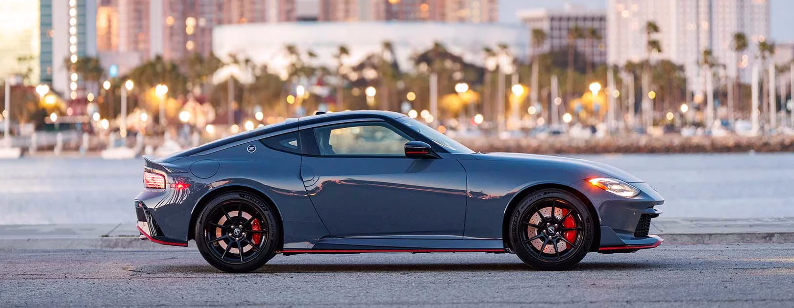 Grey Nissan Z NISMO shown in side profile beside a waterfront