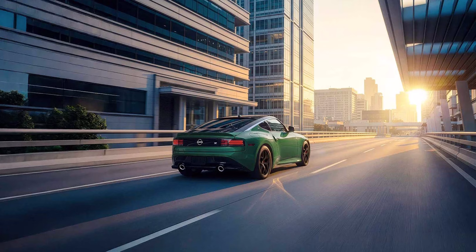 Green 2027 Nissan Z driving through a modern city at sunset