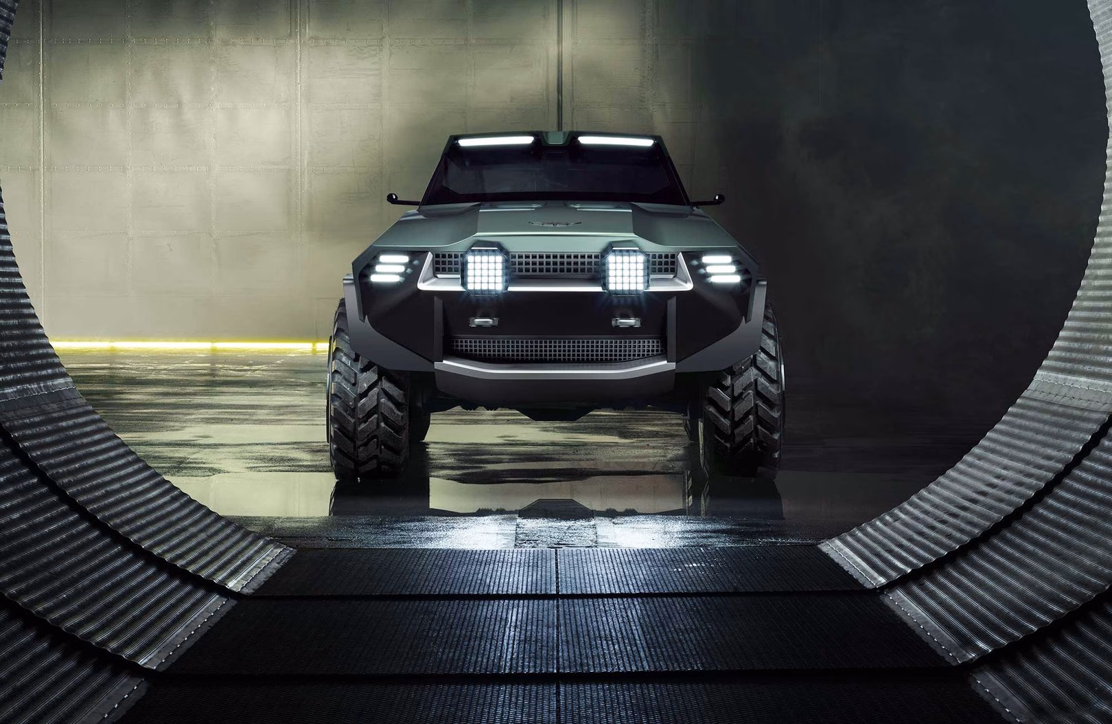 Green Aston Martin Dreadnought SUV head-on with roof and grille LED light bars illuminated, framed in a circular tunnel