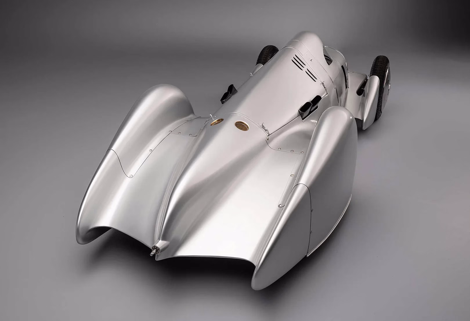 Rear three-quarter studio view of the silver Auto Union Lucca streamliner
