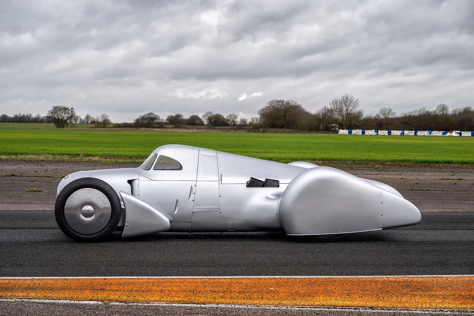 Silver Auto Union Lucca streamliner in full side profile on a test surface