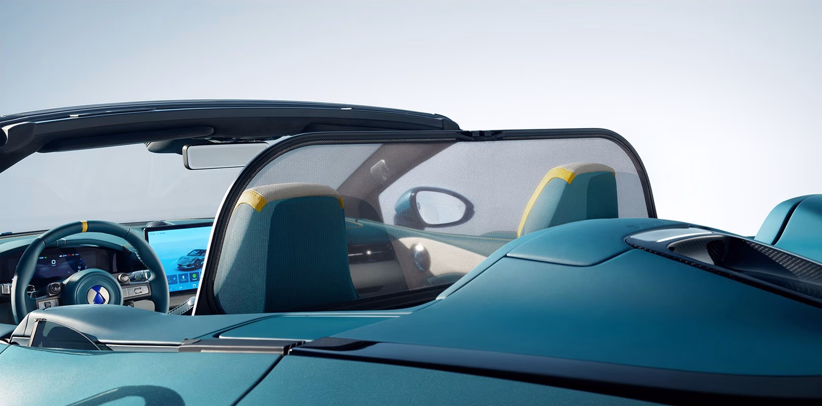 View over the teal cockpit of the BYD Denza Z Spider with the roof down, showing the dashboard and seats