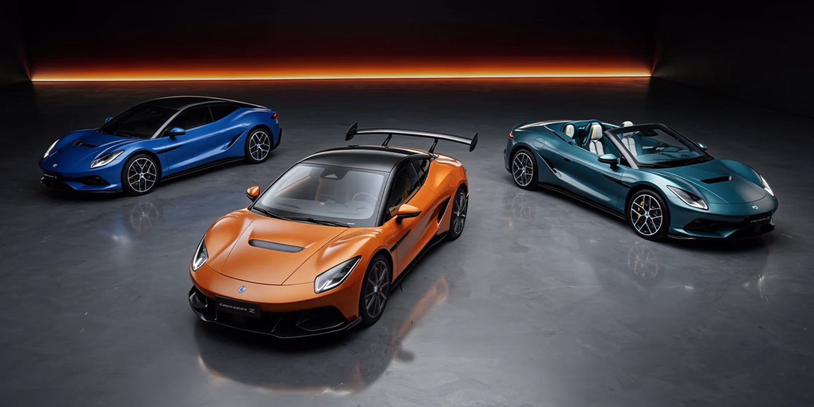 Blue BYD Denza Z coupe, orange Racing and teal Spider lined up in a dark studio