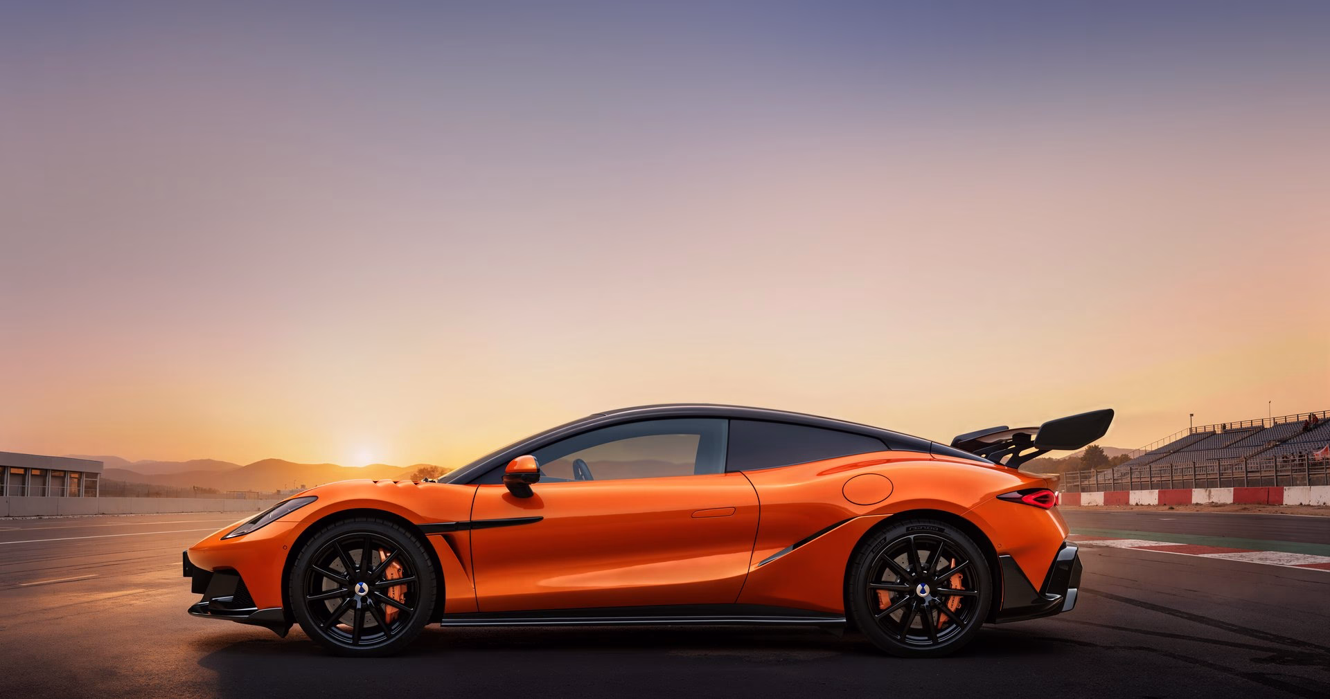Orange BYD Denza Z electric supercar in side profile on a race track at sunset, rear wing raised