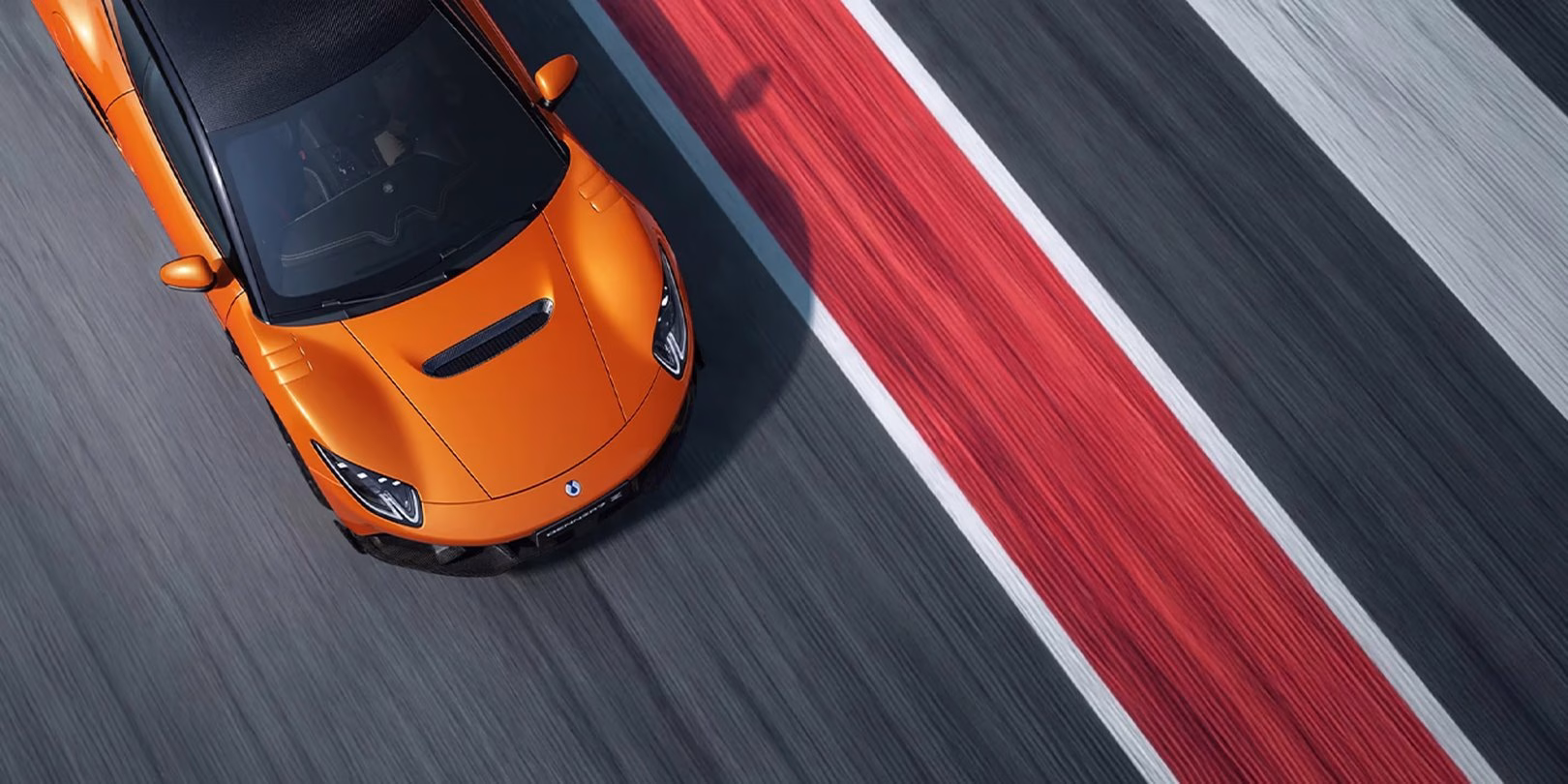 Overhead view of an orange BYD Denza Z Racing on a race track, showing the bonnet air outlets