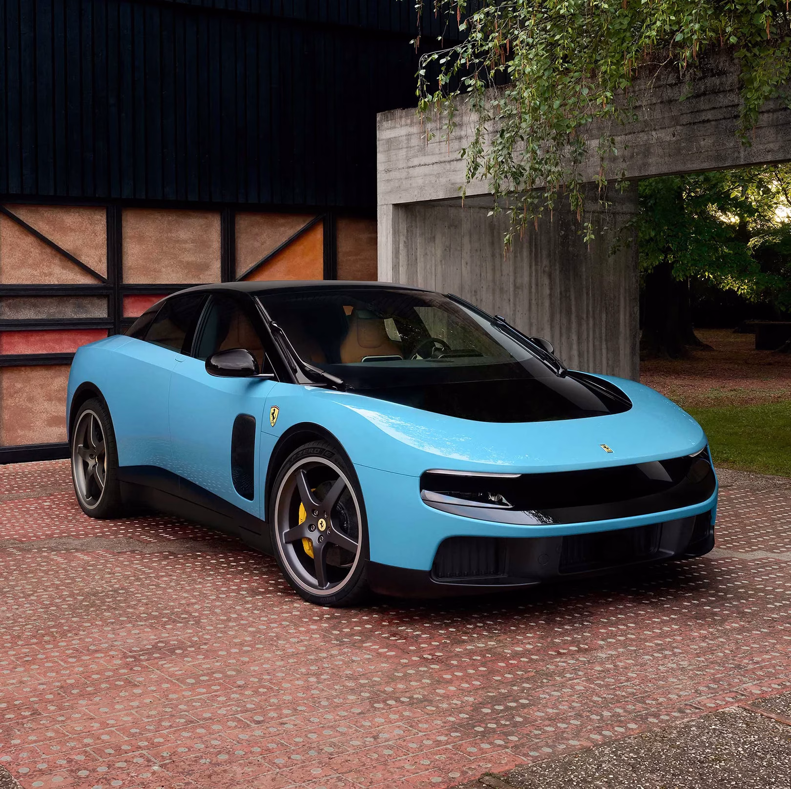 Light blue Ferrari Luce electric car front three quarter view on a brick driveway